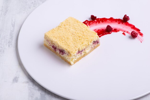 Serving of delicious vanilla rapsberry cake on a white plate