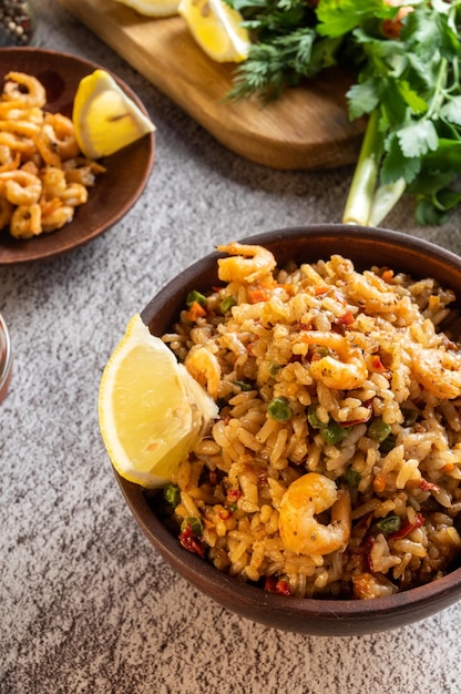 Serving the dish Paella with lemon and fried prawns Dish and herbs Vertical frame