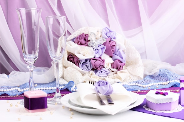 Сервировка сказочного свадебного стола в фиолетовом цвете на фоне белой ткани