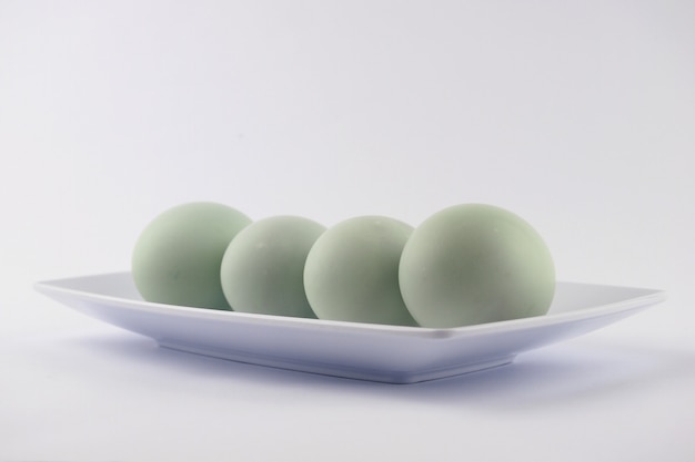 Serving fresh duck eggs on a white surface