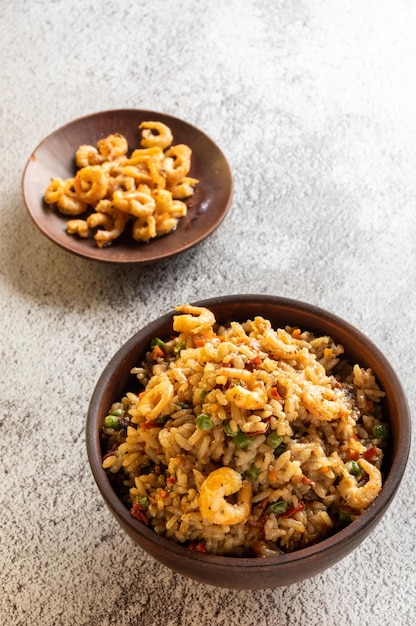 Serving paella with fried shrimp and lemon Serving food in earthenware Vertical frame