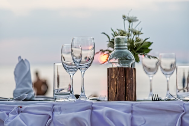 Обслуживание романтического ужина на пляже на закате