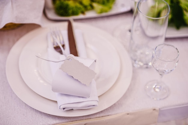 Photo serving setting table two plates and silverware cutlery linen napkin are decorated with ribbons and gift wedding table decoration close up