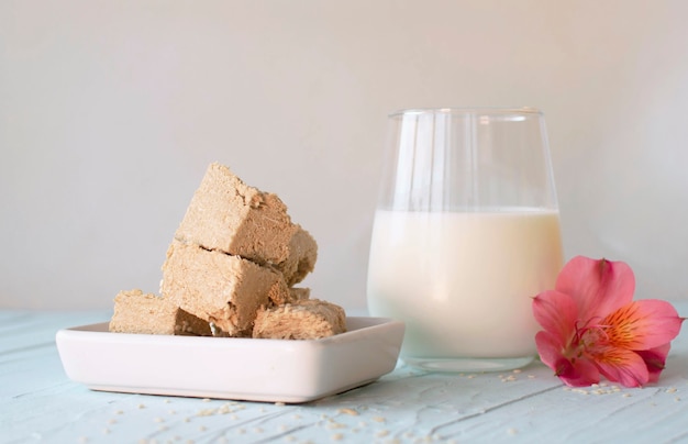 Sesame halva and a glass of milk on a blue background. Traditional Middle Eastern sweets. Jewish, Turkish, Arabic national dessert. Turkish delight.A place to copy.