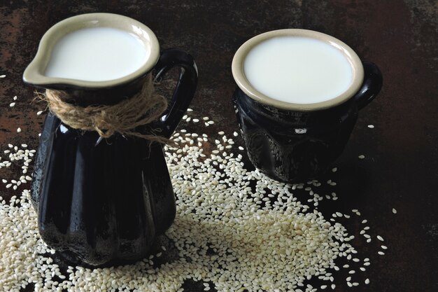 Sesame milk in a jug. Vegan drinks.