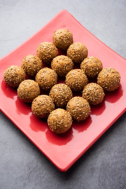 Sesame seed jaggery ball or til ke laddo and tilgul or til gul laddu served in bowl for Makar Sankranti Festival in India