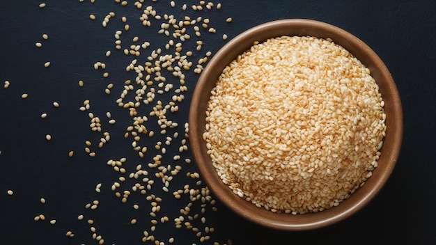 Sesame seeds in bowl on dark background