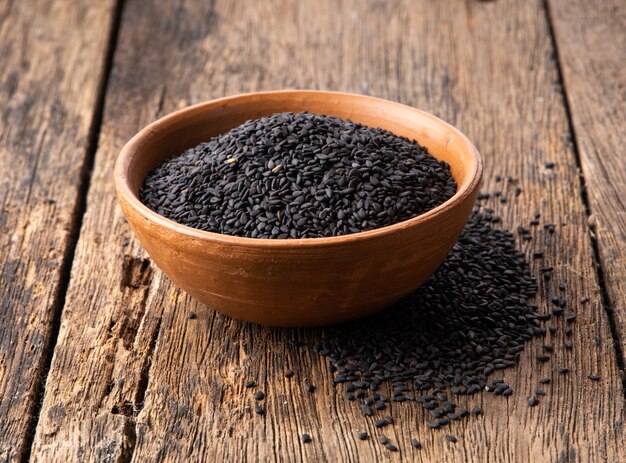 Sesame seeds in a ceramic bowl on wooden