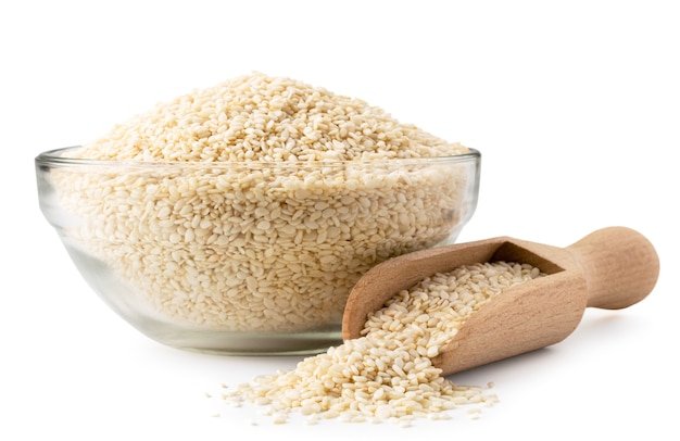 Sesame seeds in glass plate and wooden spoon