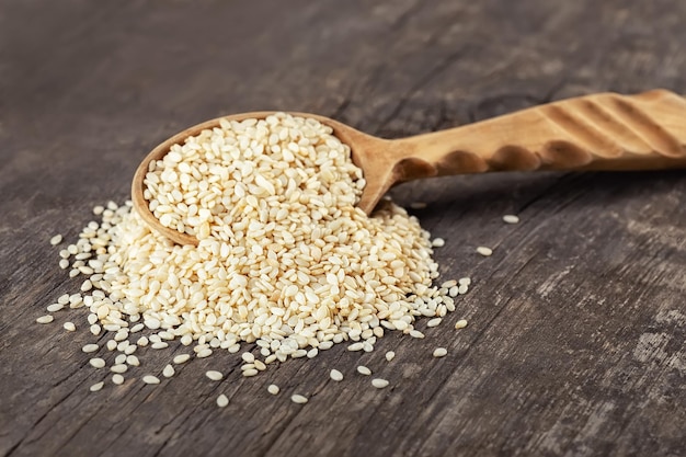 sesame seeds in spoon on wooden table