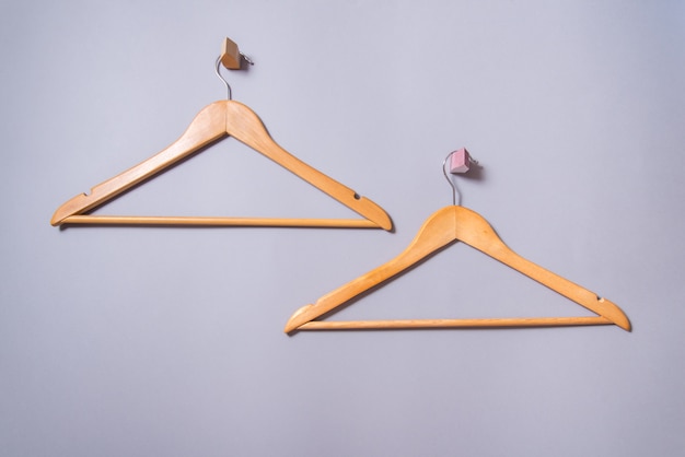 Set of 2 Empty wooden  lacquered clothes hanger hang on gray  wall background