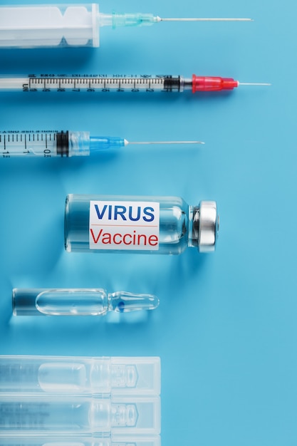 비문 바이러스 백신 및 파란색 배경에 주사기 세트와 앰플과 주사기의 집합입니다.