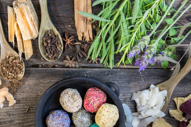 Set of aromatic incense and natural flowers and herbs on rustic wood