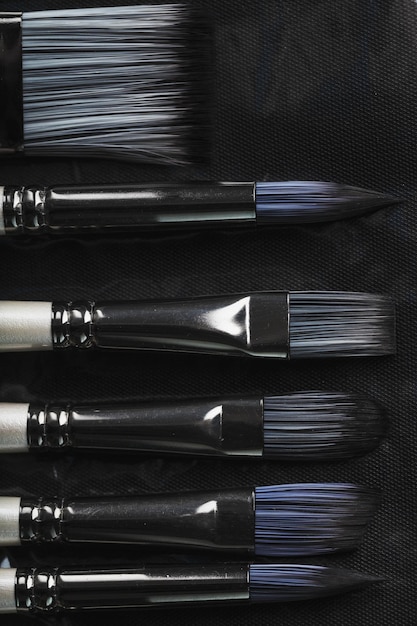 A set of art brushes for drawing on a black