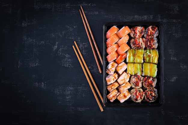 Set di cibo asiatico. sushi, rotoli su sfondo nero. vista dall'alto, sopra