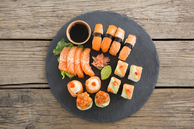 Set of assorted sushi served on black stone slate