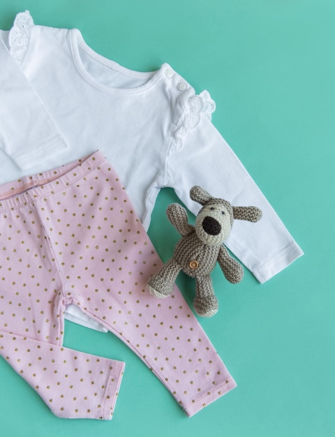 赤ちゃんのボディスーツパンツ靴下そして編み物のおもちゃのセット