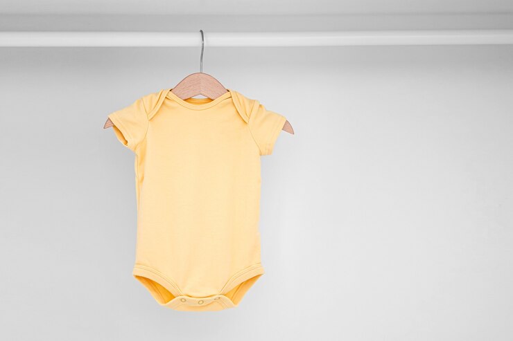 Foto set baby bodysuits voor een pasgeboren meisje en jongen op hangers in witte kledingkast. moederschap, kindergarderobe opruimen. minimaal modeconcept.