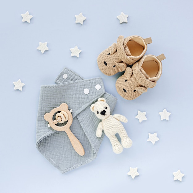 Set of baby shoes, toys and accessories on blue background. Fashion newborn stuff. Flat lay, top view