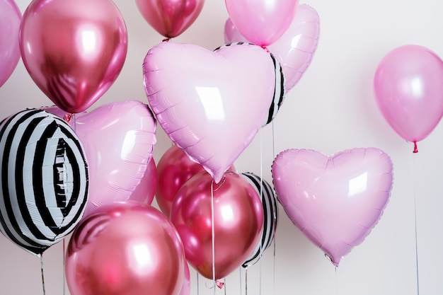 Photo set of balloons in the form of a heart and round pink and striped on light background with copy space.