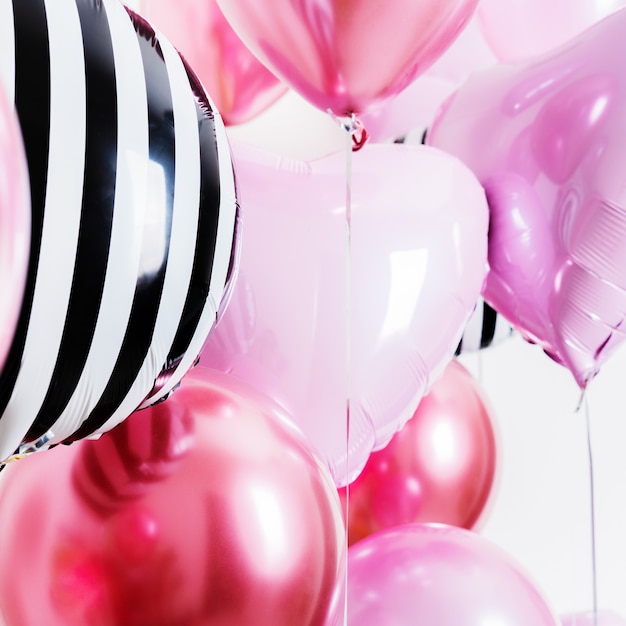 Set of balloons in the form of a heart and round pink and striped on light background with copy space.