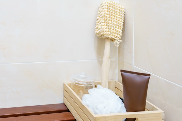 Foto set di accessori per il bagno su cesto di legno: soffio, kit per loofah spa, gel doccia, crema