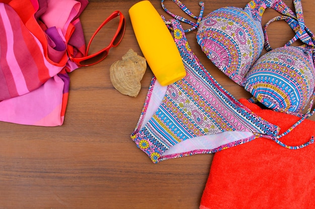 Set of beachwear on wooden background