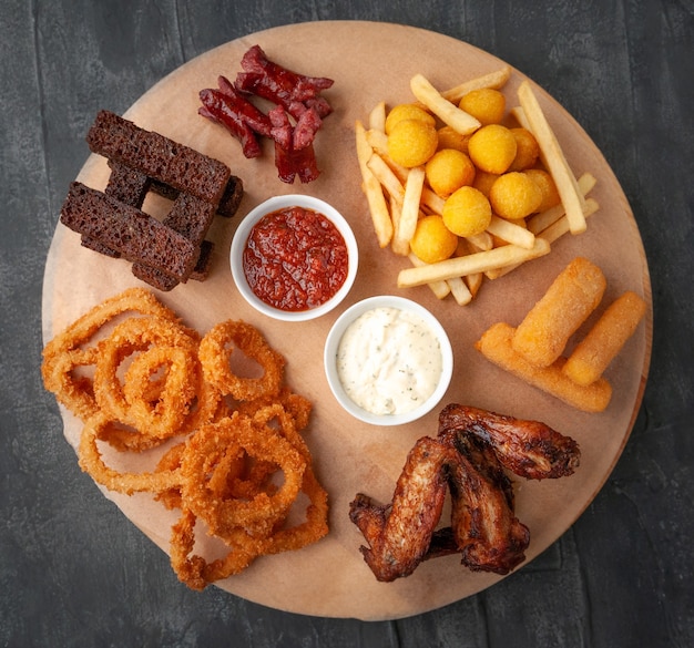 Set of beer snacks Consisting of spicy chicken wings french fries cheese sticks squid in batter