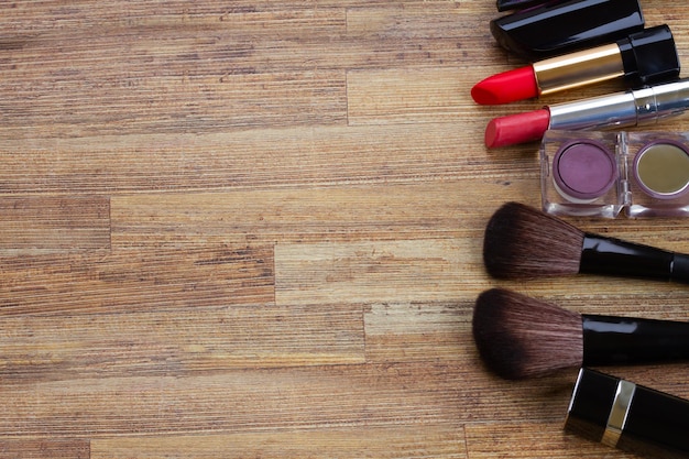 Set of black brushes and lipsticks on wooden table