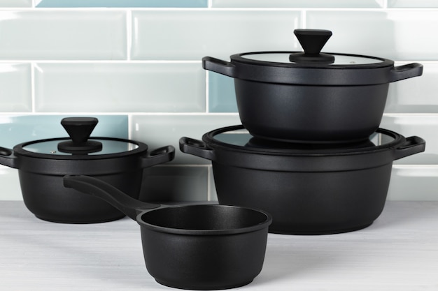 Set di pentole nere sul bancone della cucina