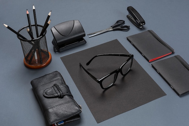 Photo a set of black office accessories, glasses on gray background. flat lay. still life. mock-up