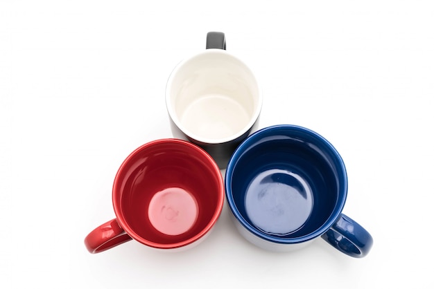 Set of black, red and blue cups on white 