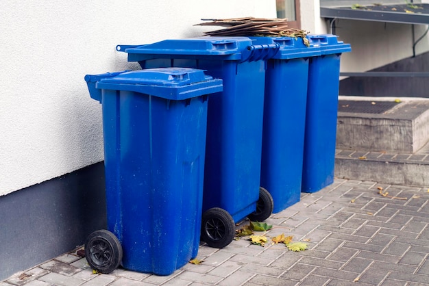 Set blauwe plastic vuilnisbakken voor afvalinzameling op een stedelijke straat