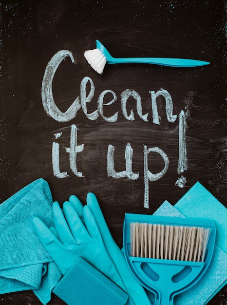 A set of blue cleaning tools around the inscription on the chalkboard.