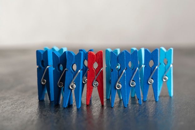 Set of blue clothespins and red clothespin on black surface