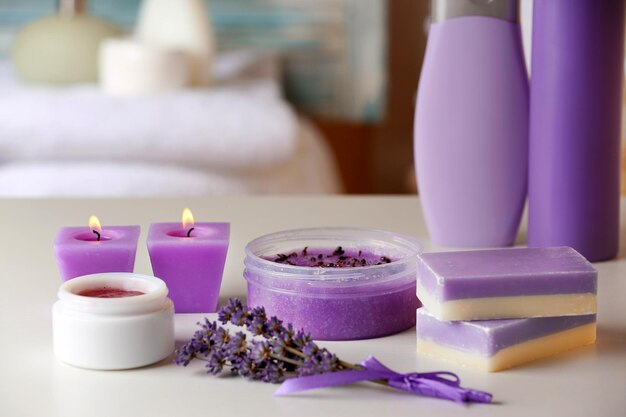 Set of body care cosmetics with lavender and candles on table