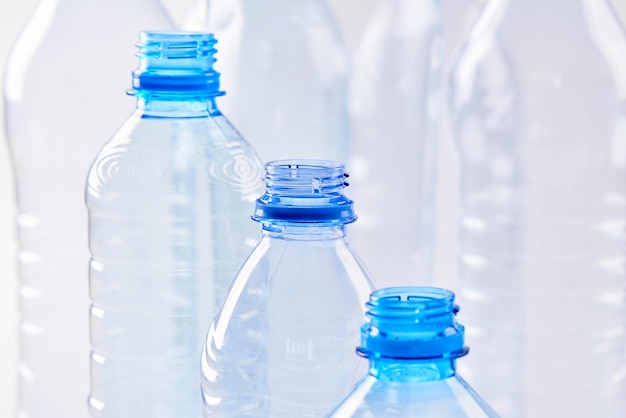 Set bottles of mineral water different types and sizes stand isolated on white background. Plastic production and processing concept