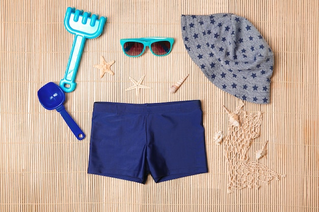 Photo set of boy's beach accessories on wicker background