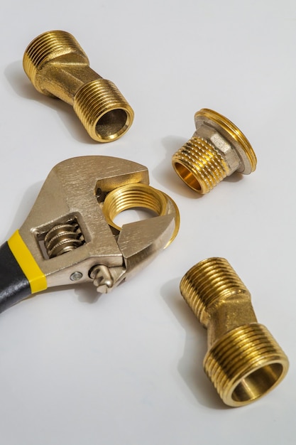 Set of brass fittings and tool is often used to connect for water and gas installations on gray background