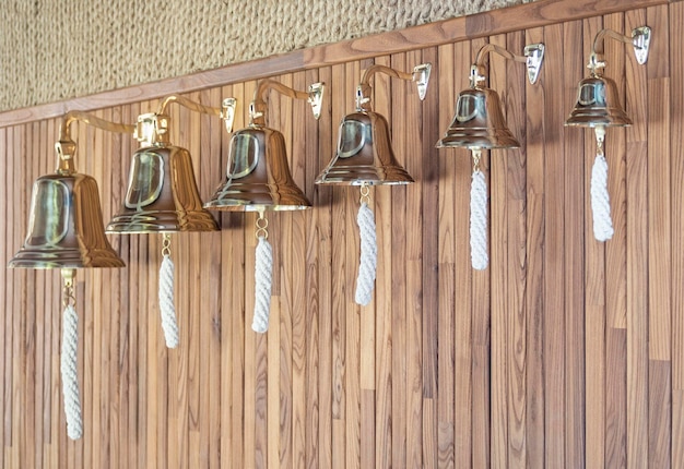 Photo set of brass ship39s bells with ropes in boat interior