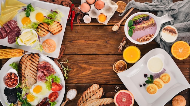 Impostare la colazione uova yogurt frutta formaggio vista dall'alto su uno sfondo di legno spazio di copia