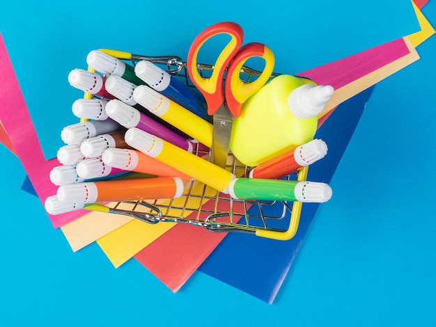 A set of bright stationery in a basket and sheets of colored paper