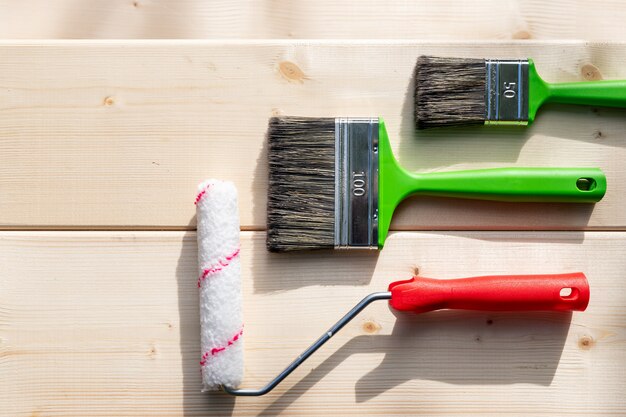 Set of brushes and roller for painting on wooden backgrond.