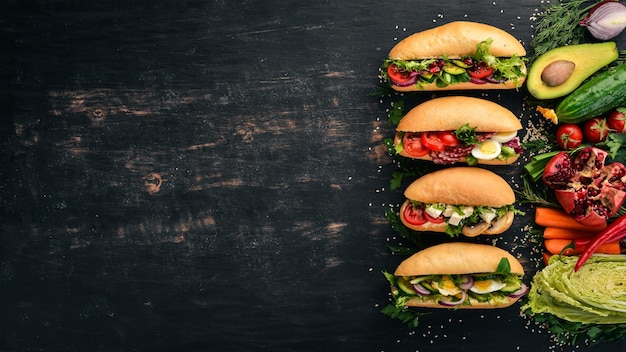 Set Burger sandwich with quail eggs cucumbers and corn salami and seafood On a wooden background Top view Copy space