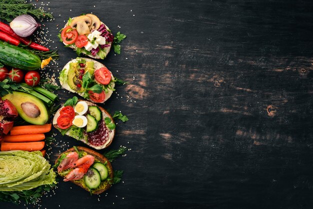 Set Burger sandwich with quail eggs cucumbers and corn salami and seafood On a wooden background Top view Copy space