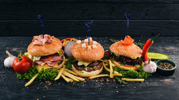 Set burgers with fish meat and vegetables top view free space\
for your text on a wooden background