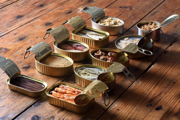 set of cans with fish and seafood on wooden, face to face