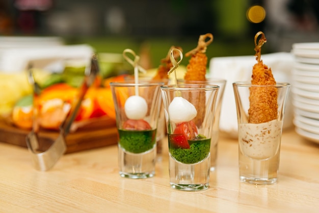 Foto set di canapé di caprese in scatti snack di festa in bicchieri su un tavolo