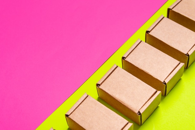 Set of cardboard boxes on pink, green background