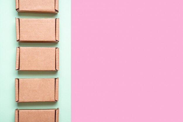 Set of cardboard boxes on pink, green background